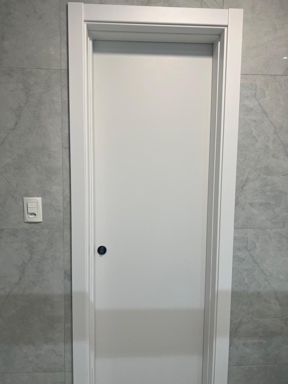Porta branca instalada em parede marmorizada