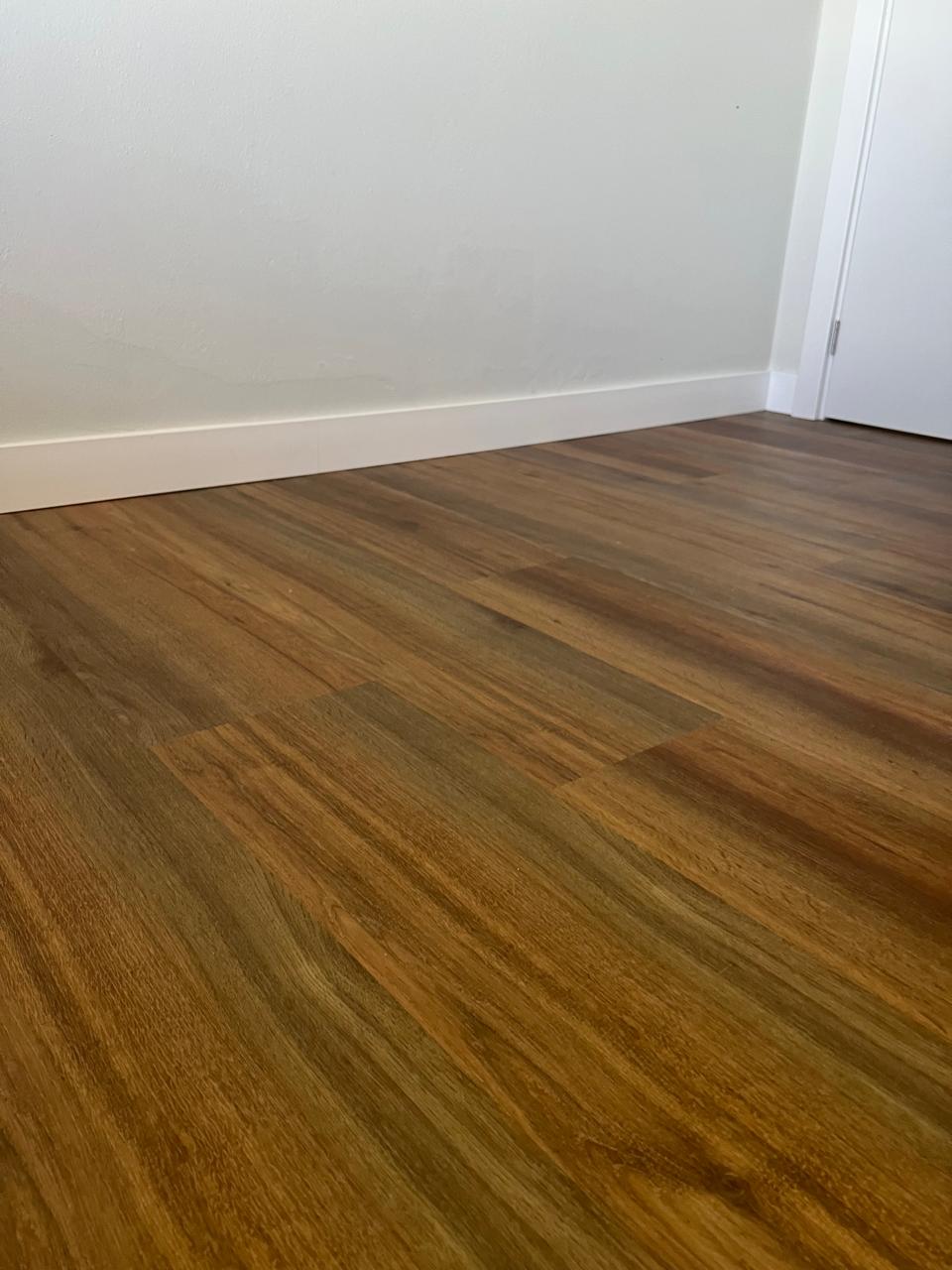 Piso vinílico tom mel com rodapé branco